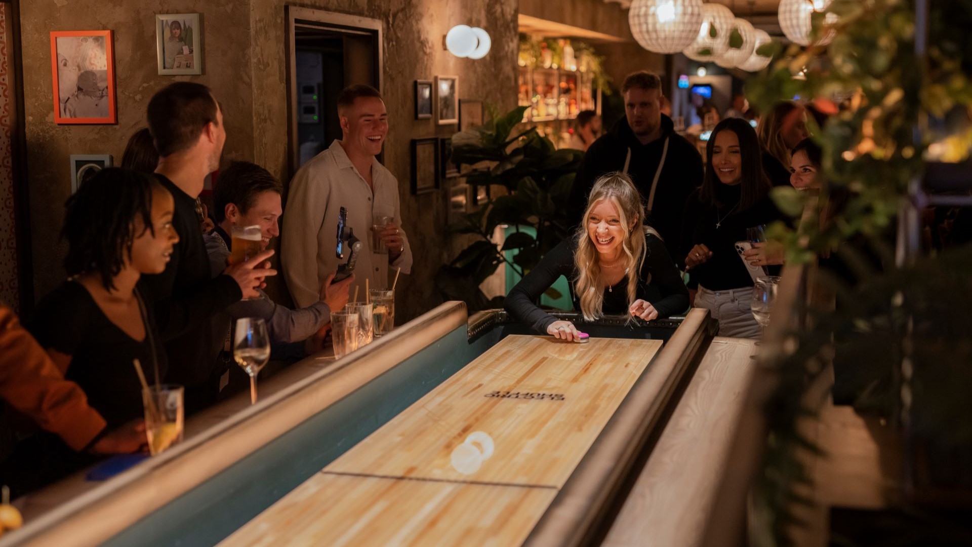 A photo of a group of people playing Electric Shuffleboard at Electric Shuffle