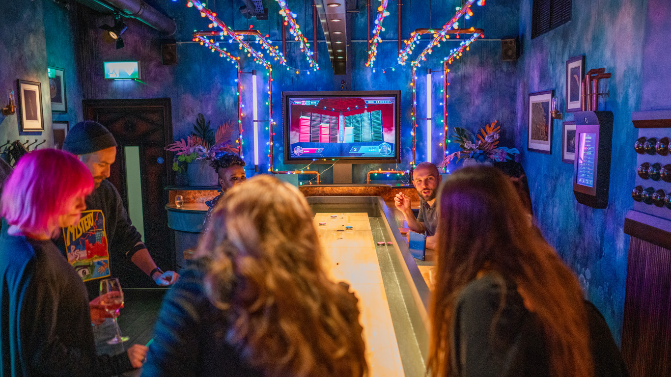 A photo of a group of people playing Electric Shuffleboard at Electric Shuffle