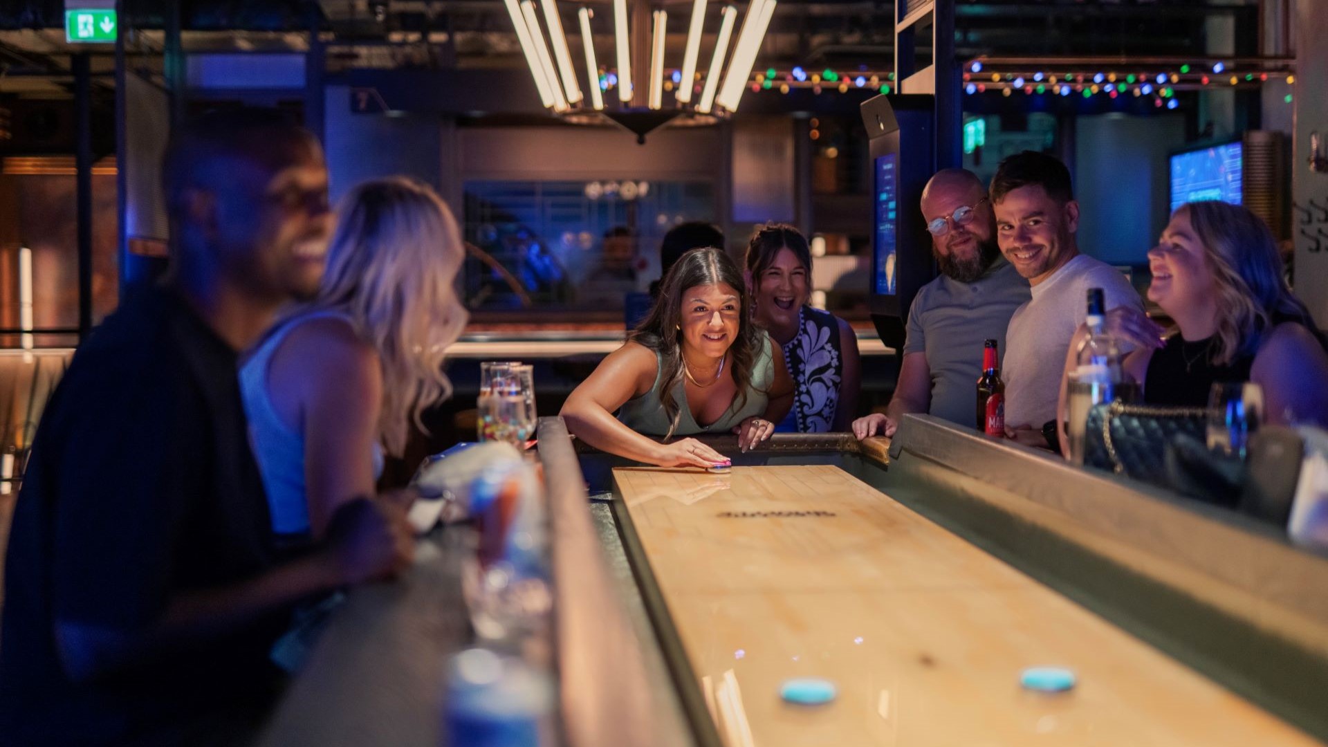 A group of people playing Electric Shuffleboard at Electric Shuffle