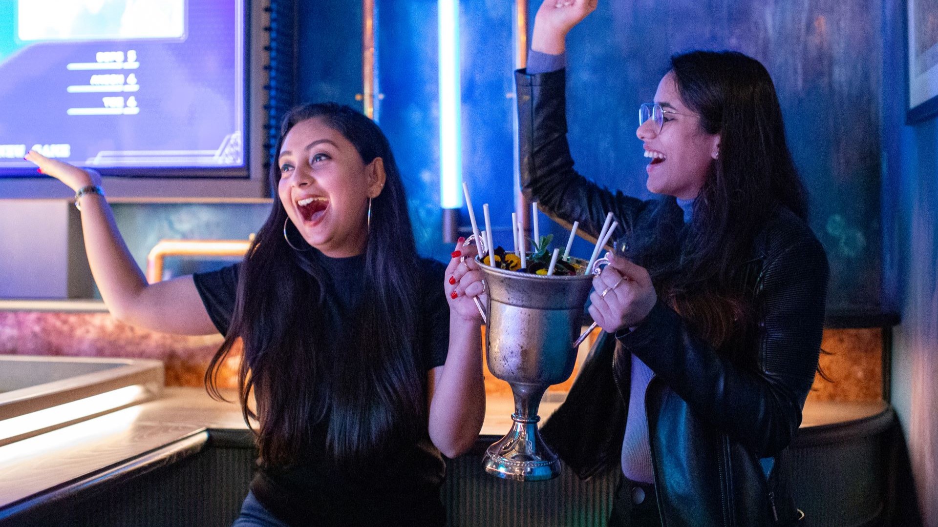 A couple of women celebrating with a Trophy Sharing Cocktail at Electric Shuffle